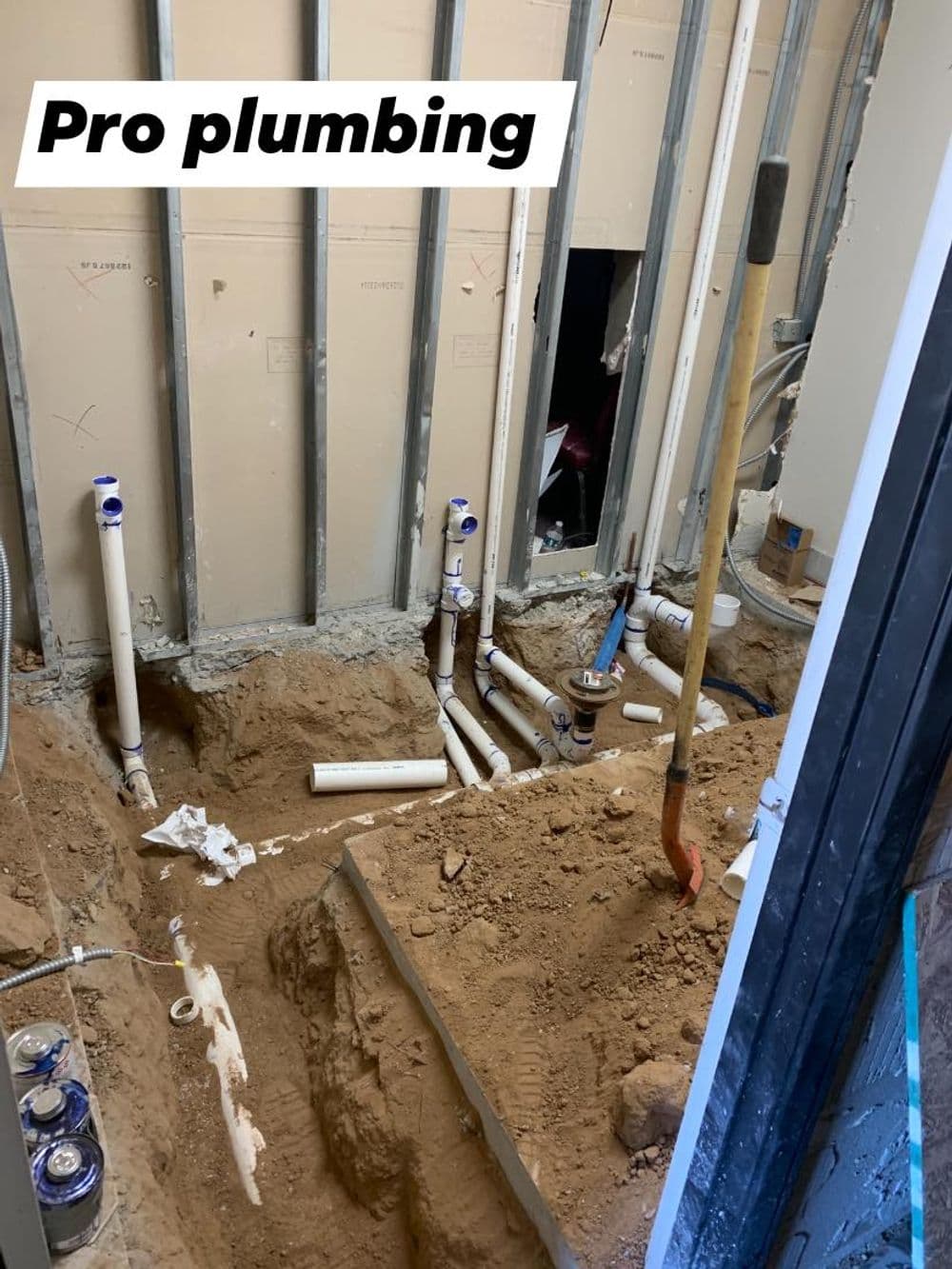 Pro plumbing showing pipes installed in a construction site with exposed dirt and tools.